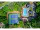 Aerial view showcasing tennis courts and a pool area surrounded by lush trees at 1099 Mount Water Ln, Lawrenceville, GA 30043