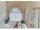 Bright bathroom with large window over the tub and a glass-enclosed shower at 1099 Mount Water Ln, Lawrenceville, GA 30043