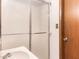 Bathroom featuring a frosted glass shower, white sink, and wood door at 2588 Shady Sw Ln, Conyers, GA 30094