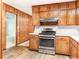 Kitchen with wooden cabinets, stainless steel oven, and wooden paneling at 2588 Shady Sw Ln, Conyers, GA 30094