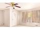 Living room with neutral carpeting and a ceiling fan, next to front door and windows at 2588 Shady Sw Ln, Conyers, GA 30094