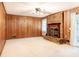 Cozy living room featuring a brick fireplace, wood paneling, and neutral carpet at 2588 Shady Sw Ln, Conyers, GA 30094