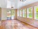 A sun room with hardwood flooring, paneled walls, and windows overlooking the yard at 2588 Shady Sw Ln, Conyers, GA 30094