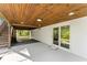 Rear patio with wood ceiling, concrete, double glass doors, and outdoor access at 2120 Pair Sw Rd, Marietta, GA 30008