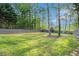 A large, grassy backyard is surrounded by a wooden fence and mature trees and shrubbery at 2164 Caneridge Sw Dr, Marietta, GA 30064