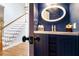 Stylish half bathroom with navy blue vanity and decorative mirror at 2164 Caneridge Sw Dr, Marietta, GA 30064