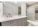 Bright bathroom featuring double vanity with gray cabinets, white countertop, and shower with glass doors at 2164 Caneridge Sw Dr, Marietta, GA 30064