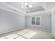 Bright bedroom with tray ceiling, modern light fixture, neutral carpet, and natural light from the window at 2164 Caneridge Sw Dr, Marietta, GA 30064