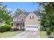 Beautiful home showcasing stone accents, a covered front porch, a lush lawn, and an attached garage at 2164 Caneridge Sw Dr, Marietta, GA 30064