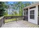 Spacious screened in porch features wooden railing, access to a fenced in yard, and wooded views at 2164 Caneridge Sw Dr, Marietta, GA 30064