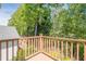 Outdoor deck with wood railing and view of mature trees at 235 Cornerstone Dr, Woodstock, GA 30188
