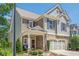 Beautiful home with stone accents, a covered front porch, and professional landscaping at 235 Cornerstone Dr, Woodstock, GA 30188
