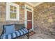 Cozy front porch with stone facade, a comfortable bench, and a welcoming entrance at 235 Cornerstone Dr, Woodstock, GA 30188