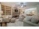 Cozy living room with stone fireplace, custom built-ins, plush seating, and view to dining area at 235 Cornerstone Dr, Woodstock, GA 30188