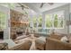 Bright sunroom featuring a stone fireplace, vaulted ceilings, and abundant natural light at 235 Cornerstone Dr, Woodstock, GA 30188