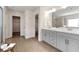 Well-lit bathroom featuring double sinks, a large mirror, and tile floors at 3051 Mountain Shadow Way, Marietta, GA 30064
