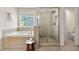 Bright bathroom showcasing a soaking tub, glass-enclosed shower, and large window at 3051 Mountain Shadow Way, Marietta, GA 30064