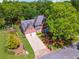 Aerial view of a brick two-story home, showcasing its manicured lawn, two-car garage, and inviting driveway at 579 Delphinium Nw Blvd, Acworth, GA 30102
