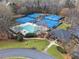 Aerial view of community pool, tennis courts, community building, and mature trees at 579 Delphinium Nw Blvd, Acworth, GA 30102