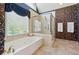 The main bathroom features a glass enclosed shower, soaking tub, and elegant wallpaper at 579 Delphinium Nw Blvd, Acworth, GA 30102