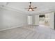 Spacious main bedroom featuring tray ceilings, neutral paint, a ceiling fan, and ensuite bathroom access at 579 Delphinium Nw Blvd, Acworth, GA 30102