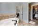 Spa-like bathroom with a soaking tub, tile surround, separate shower, and walk-in closet at 735 Neel Reid Dr, Roswell, GA 30075
