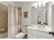 Clean bathroom featuring a shower-tub combo and a decorative mirror at 735 Neel Reid Dr, Roswell, GA 30075