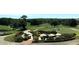 View of a golf course with lush greenery, trees, and seating area with tables and chairs at 735 Neel Reid Dr, Roswell, GA 30075