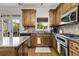 Kitchen features wooden cabinets, stainless appliances, granite countertops, and breakfast area at 735 Neel Reid Dr, Roswell, GA 30075