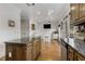 Open kitchen with granite counters and wooden cabinets, flowing into breakfast nook with seating and tv at 735 Neel Reid Dr, Roswell, GA 30075