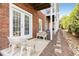 Outdoor patio with cast iron chairs, brick exterior, and landscaping at 735 Neel Reid Dr, Roswell, GA 30075