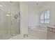All-white bathroom with glass shower and soaking tub under window at 1153 Brookhaven Commons Ne Dr, Brookhaven, GA 30319