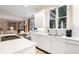 Bright eat-in kitchen featuring white cabinets, a marble island, and views to the living room at 1153 Brookhaven Commons Ne Dr, Brookhaven, GA 30319