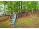 Backyard playground with slide and swings, surrounded by a wooden fence at 1988 Claiborne Ct, Marietta, GA 30062