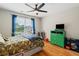 Comfortable bedroom with ceiling fan, hardwood floors, and charming blue curtains at 1988 Claiborne Ct, Marietta, GA 30062