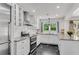 Bright, white kitchen features modern appliances, black marble floor, and a window overlooking lush greenery at 2495 Northlake Ne Ct, Atlanta, GA 30345