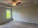 Carpeted bedroom with a tray ceiling and a window overlooking a green lawn at 4120 Chapel Hill Reserve, Douglasville, GA 30135