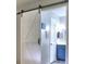 Bathroom featuring a sliding barn door and vanity with blue cabinets at 4579 Amberly S Ct, Atlanta, GA 30360