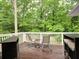Spacious deck with multiple seating areas surrounded by lush green trees in the background at 4579 Amberly S Ct, Atlanta, GA 30360