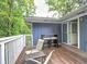 Outdoor deck with a cozy seating arrangement and a view of the lush green trees at 4579 Amberly S Ct, Atlanta, GA 30360