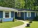 Close-up view of the house showcasing the blue exterior, white trim, and a neatly landscaped walkway at 4579 Amberly S Ct, Atlanta, GA 30360