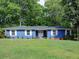 Charming blue ranch-style home featuring a lush lawn, classic white windows, and a welcoming front entrance at 4579 Amberly S Ct, Atlanta, GA 30360