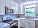 Up close view of kitchen features stainless steel oven, sink, and white cabinets at 4579 Amberly S Ct, Atlanta, GA 30360