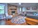 Cozy living room featuring a brick fireplace, hardwood floors, and comfortable seating area at 4579 Amberly S Ct, Atlanta, GA 30360