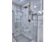 Elegant shower with white marble tile and brass fixtures at 4579 Amberly S Ct, Atlanta, GA 30360