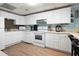 Eat-in kitchen with white cabinets, appliances, and neutral countertops at 737 Dushea Nw Ct, Kennesaw, GA 30144