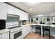 Bright eat-in kitchen featuring white cabinets, appliances, and bar seating at 737 Dushea Nw Ct, Kennesaw, GA 30144
