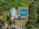 Aerial view of the community pool, tennis courts, parking, and clubhouse surrounded by lush green trees at 1819 Walker Ridge Sw Dr, Marietta, GA 30064