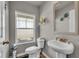 Cozy half-bathroom features a pedestal sink, toilet, and window with decorative shelves at 206 Prescott St, Locust Grove, GA 30248
