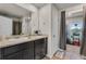 Bathroom with dual sinks, dark vanity, and separate room for toilet and shower at 206 Prescott St, Locust Grove, GA 30248